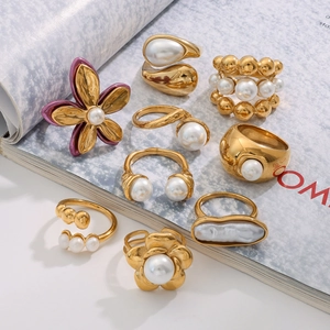 Artistic collection of 18k gold plated stainless steel pearl rings on an open magazine