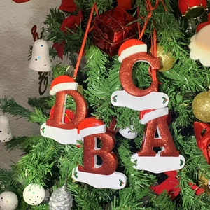 Detail of red glitter Christmas letters A-D with Santa hats hanging on a tree