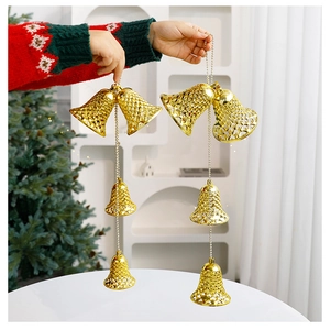 Detail of a tiered golden Christmas bell ornament featuring hollow patterns and bead chains