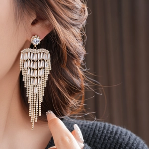 Close-up of elegant gold tassel earrings featuring sparkling zircon crystal fringes