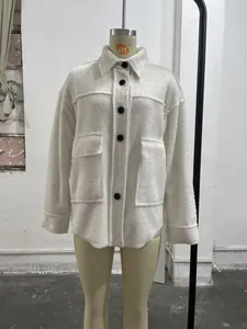 Close-up of white faux fur jacket featuring large lapels and black contrast buttons