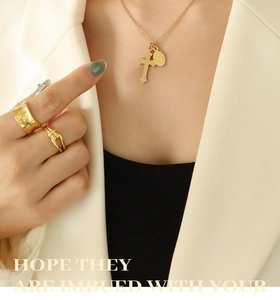 Détails d'un collier vintage doré avec pendentif croix et bagues texturées assorties