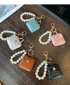 Macro detail of crocodile texture mini bags with pearl handles in various colors