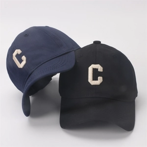 Detail of navy and black cotton baseball caps with 3D embroidered C letter