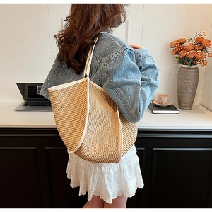 Large capacity beige straw shoulder bag with white trim shown in daily use scenario