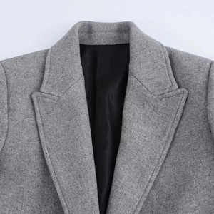 Close-up of grey wool coat featuring notched lapels and high-quality fabric texture