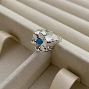 Detail view of flower ring with turquoise gemstone and adjustable 925 silver open band