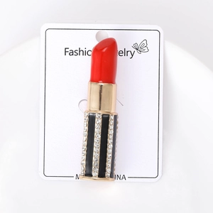 Detailansicht der Lippenstift-Brosche mit roter Emaille und funkelnden Strassstreifen