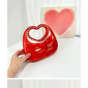 Detail of red marble texture heart-shaped handbag with rhinestone handle design