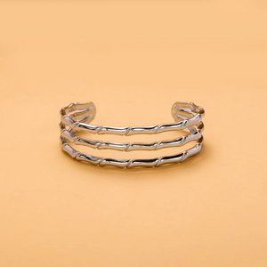 Macro detail of the triple-layer silver cuff bracelet with bamboo texture and open design
