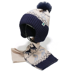 Détail de l'ensemble bonnet et écharpe en tricot dinosaure avec cache-oreilles bleus