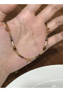 Detailed view of handmade beaded necklace with gold-plated tubes and tiger eye beads