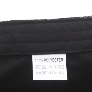 Detail view of care label inside the plaid newsboy cap showing 100% polyester material