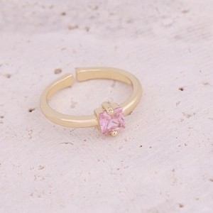 Detail of adjustable gold ring featuring a square pink zircon stone and metallic band