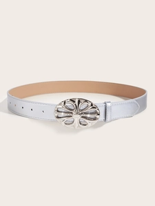 Detail shot of vintage silver flower buckle with rhinestones on black PU leather belt