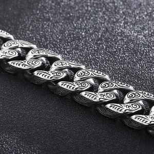 Detail of vintage silver double snake head Cuban chain bracelet with intricate engravings