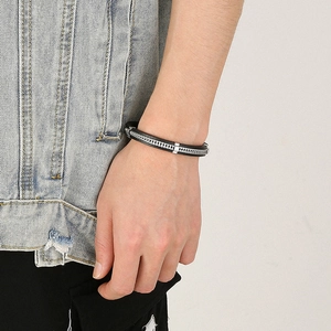 Close-up of a men's woven black leather bracelet with a polished silver steel chain