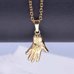 Macro shot of gold Hamsa Hand pendant with Eye of Providence detail on black leather