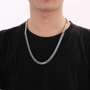 Close-up of polished silver stainless steel curb chain on male neck in professional studio