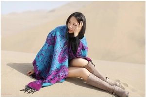 Ethnic paisley cashmere shawl with black tassels worn by a model in a desert landscape