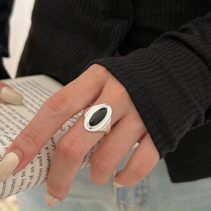Detail of a 925 sterling silver ring with oval black onyx gemstone on a hand