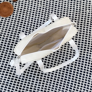 Top view of white canvas ita bag showing internal zipper and spacious storage compartment