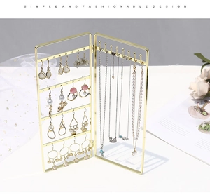 Detail of golden foldable jewelry stand with screen design for earrings and necklaces