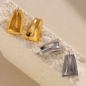 Macro detail of geometric trapezoid earrings in 18K gold and silver stainless steel