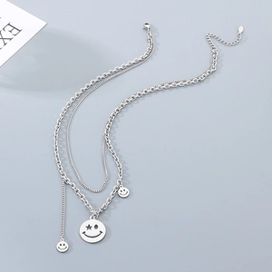 Double-layered silver smiley face necklace with star-eye pendants in minimalist hip-hop style