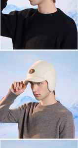 Detail of white knit winter trapper hat with ear flaps and leather logo patch