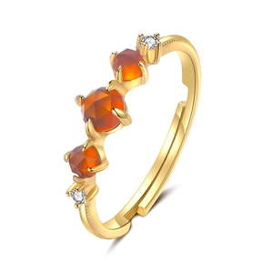 Elegant gold-tone ring with three orange garnets and white diamond accents on white