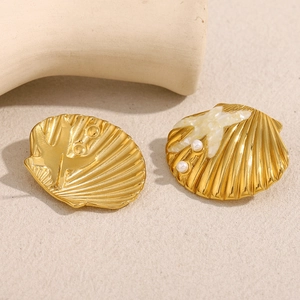 Detail of 18K gold plated starfish shell earrings with inlaid pearls and glossy finish