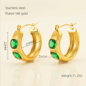 Détail de créoles épaisses plaquées or 18 carats avec zircon vert coupe émeraude