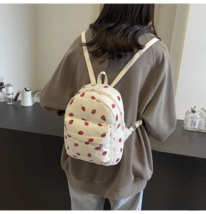 Detailed back view of a white corduroy backpack with strawberry print and adjustable straps