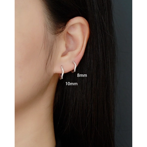 Detail view of wavy S925 silver hoop earrings with pavé diamonds in 8mm and 10mm sizes