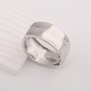 Macro shot of polished silver metal ring featuring a minimalist wavy surface texture