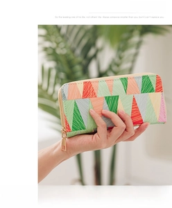 Detail of colorful geometric triangle patterned long wallet with gold zipper and texture