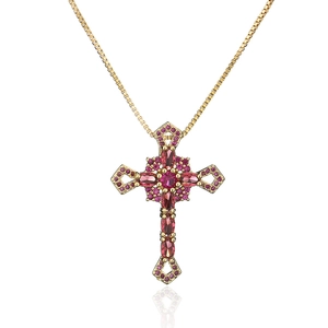 Makroaufnahme von 18K vergoldetem Kreuzanhänger mit rosa Zirkonia an einer Goldkette