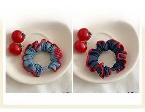 Detailed macro view of denim scrunchies set with red contrast stitching and ruffled edges