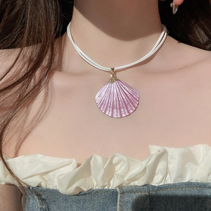 Close-up of a iridescent purple shell pendant necklace worn on a model for beach style