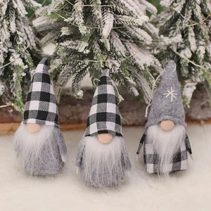 Three Christmas gnomes with plaid and gray felt hats on a snowy holiday background