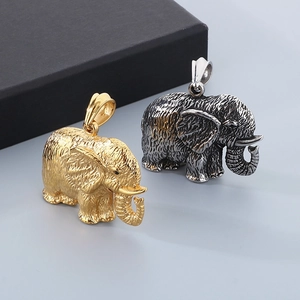 Macro detail of gold and silver elephant pendants with intricate texture and trunk up
