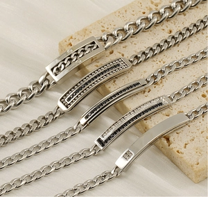 Dettaglio di bracciali a catena cubana argento con diverse barre tempestate di diamanti