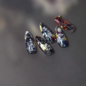 Detail of gothic long stiletto press-on nails with dark red hand-painted character art