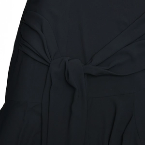 Detailed close-up of a stylish black waist tie knot on a sheer summer halter dress