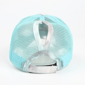 Detail of light blue mesh trucker hat with tie-dye ponytail opening and velcro strap