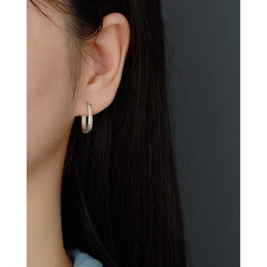Close-up of minimalist S925 sterling silver U-shaped stud earrings worn on ear