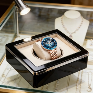 Detail of rose gold watch with blue diamond-cut dial in luxury rotating watch box