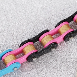 Vue macro d'un bracelet chaîne de vélo en acier coloré avec maillons rose, bleu et or