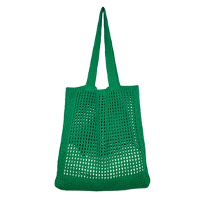 Detail view of vibrant green hand-crocheted knit bag with a hollow diamond mesh texture